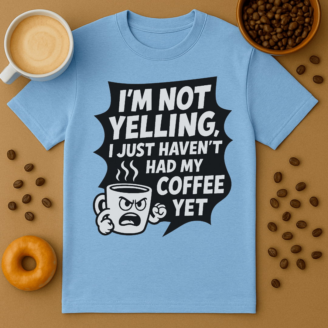 Blue t-shirt with coffee-themed graphic and text on a brown background with coffee beans and a donut.