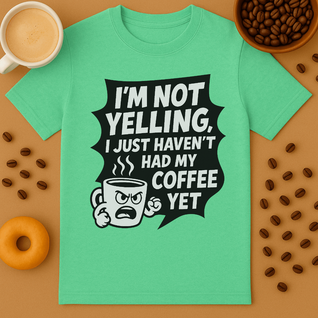 Green t-shirt with coffee-themed graphic and text on a brown background with coffee beans and a donut.